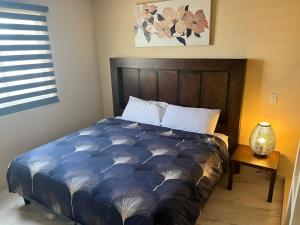 a bed with a blue comforter in a bedroom at Ancla Suites Urban Hotel - 6 in Puerto Peñasco