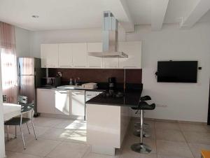 a kitchen with white cabinets and a black counter top at Le lagon de Hammamet in Hammamet