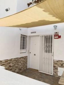2 Camere Splendida casa vacanze in Tenerife del Sur Casa Micia في أرونا: غرفة ذات باب أبيض وسقف