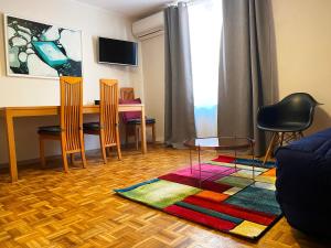 a living room with a table and chairs and a rug at Laterale Residences Riquewihr in Riquewihr