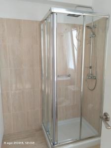 La salle de bains est pourvue d'une douche avec une porte en verre. dans l'établissement 2 Camere Splendida casa vacanze in Tenerife del Sur Casa Micia, à Arona