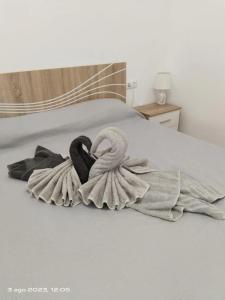 dos cisnes envueltos en una manta en una cama en 2 Camere Splendida casa vacanze in Tenerife del Sur Casa Micia, en Arona