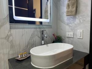 a bathroom with a white sink and a mirror at Ancla Suites Urban Hotel - 6 in Puerto Peñasco