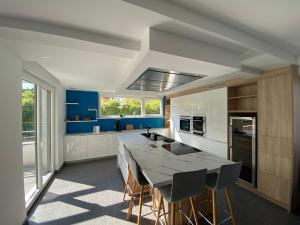 a kitchen with a large table and some blue at Villa exclusive 10 pers, garages, 10 min de la cathédrale in Strasbourg