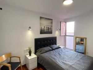 a bedroom with a bed and a chair and a mirror at Bright lovely quiet flat very centric in SC in Santa Cruz de Tenerife +32 photos