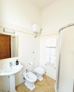 a white bathroom with a toilet and a sink at Cimabue 9 in Florence