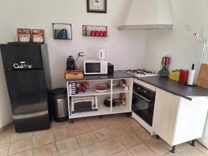 a kitchen with a microwave and a refrigerator at Appartement Stockholm in Gap +4 photos