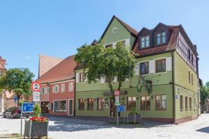 ein grünes Gebäude an der Straßenseite in der Unterkunft Goldener Schwan Hotel Garni in Bad Windsheim