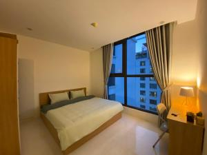 a bedroom with a bed and a large window at Housinco Premium - Serviced Apartments Nguyễn Xiển Street near Tops Market in Hanoi
