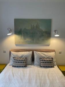 a bed with two pillows and a painting on the wall at Barn conversion, Old Hatfield, Herts Just a few minutes walk to Hatfield train station and Hatfield House in Hatfield