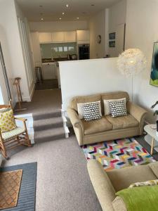 a living room with two couches and a staircase at Barn conversion, Old Hatfield, Herts Just a few minutes walk to Hatfield train station and Hatfield House in Hatfield