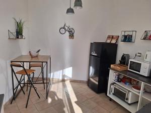 a kitchen with a refrigerator and a table and a microwave at Appartement Stockholm in Gap