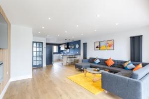 Stylish & modern 4-bedroom home with sea views في برايتون أند هوف: غرفة معيشة مع أريكة وطاولة