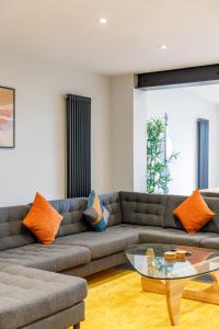 a living room with a couch and a glass table at Free Parking Stylish & modern 4-bedroom home with sea views in Brighton & Hove