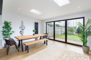 ein Esszimmer mit einem Tisch und Stühlen sowie einem großen Fenster in der Unterkunft Stylish & modern 4-bedroom home with sea views in Brighton & Hove