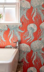 a bathroom with a red and white wallpaper with tentacles at No93 Boutique Guest House in Easingwold