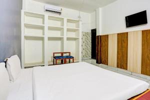 una camera con letto bianco e TV di OYO Hotel The Selaqui Paradise a Jhājra