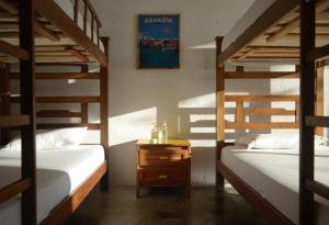 a room with two bunk beds and a table with a night stand at Playa del Ritmo Beach Hostel & Bar - Adults Only in Santa Marta