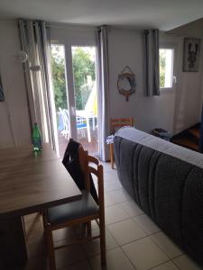 a living room with a couch and a table and chairs at ARRETEZ VOUS A OLERON in Le Château-dʼOléron +14 photos