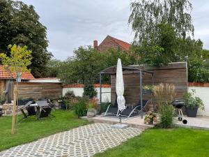 a garden with a gazebo with chairs and an umbrella at Gemütliche Ferienwohnung in Wernigerode