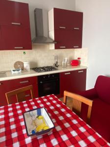a kitchen with red cabinets and a table with a plate on it at CASA ALTOMARE in Otranto