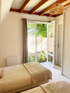 a bedroom with a bed and a large window at Chalet en Normandie au coeur du pays d'Auge in Le Pin