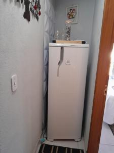 - un réfrigérateur blanc dans l'angle de la chambre dans l'établissement Casa da Joana, à Monte Verde