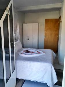 - une chambre avec un grand lit blanc et un miroir dans l'établissement Casa da Joana, à Monte Verde