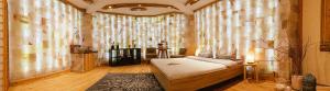 um quarto com uma cama num quarto com janelas em Salzturm der Salzmanufaktur MV em Trinwillershagen