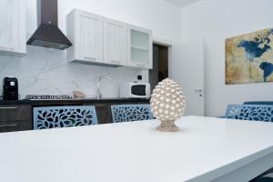 una cucina con armadi bianchi e piano di lavoro bianco di La Maison Apparthotel a Praia a Mare