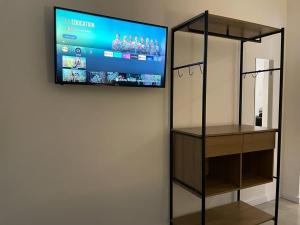 a flat screen tv on a wall with a shelf at VILLA BILAC 01 - Studio próximo à Vila Germânica in Blumenau