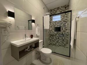 uma casa de banho branca com um lavatório e um WC em VILLA BILAC 01 - Studio próximo à Vila Germânica em Blumenau
