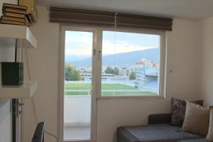 a room with a window with a couch and a view at Dino's apartment in Skopje