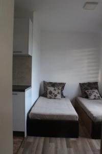 um pequeno quarto com 2 camas e uma cozinha em Dino's apartment em Skopje