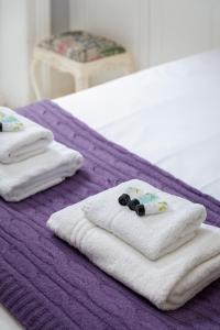 - 2 serviettes blanches sur une couverture violette sur un lit dans l'établissement Hove garden flat, pet friendly, à Brighton et Hove