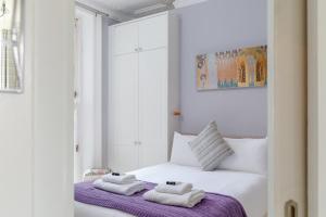 a white bedroom with towels on a bed at Hove garden flat, pet friendly in Brighton & Hove