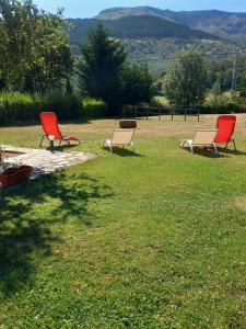 three chairs sitting in the grass in a field at El Molino de Candelario in Candelario