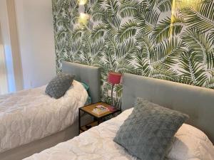 1 Schlafzimmer mit 2 Betten und einer Wand mit Wandbild in der Unterkunft Amazing Luxury Seafront Villa near Golf & Ocean in San Miguel de Abona + 116 Fotos