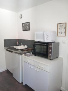 a kitchen with a microwave and a stove top oven at Studio bleu tout équipé avec wifi in Le Creusot