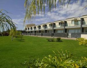 ein großes Gebäude mit grünem Rasen davor in der Unterkunft Amazing Luxury Seafront Villa near Golf & Ocean in San Miguel de Abona