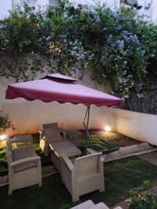 un patio con sombrilla, sillas y mesa en S+2 manzah 7 bis, en Túnez