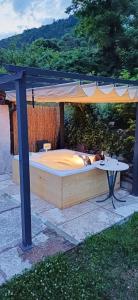 a bed in a gazebo with a table at Agritur Cantina Romanese in Levico Terme