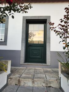 una puerta verde en un edificio con ventana en Quinta' Home, en Ribeira da Janela