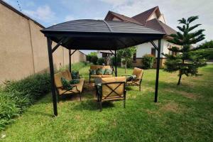 un cenador negro con sillas y mesas en un patio en Aspen Luxury Villa, en Accra
