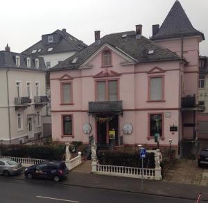a pink house with cars parked in front of it at Jugendstil Apartment in Bad Nauheim