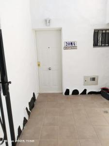 Cette chambre blanche dispose d'une porte et de carrelage. dans l'établissement 2 Camere Splendida casa vacanze in Tenerife del Sur Casa Trilly, à Arona