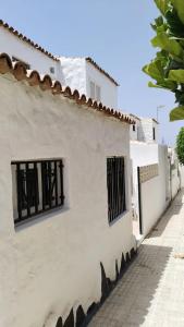 a white building with windows on the side of a street at 2 Camere Splendida casa vacanze in Tenerife del Sur Casa Trilly in Arona