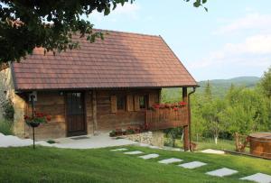 a small house with a balcony with red flowers at Javor Holiday House in Žumberak +32 photos