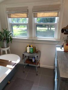 a kitchen with two windows and a table in a room at Gingerbird Art Suite in Laurel