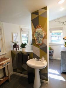 a bathroom with a sink and a mirror on a wall at Gingerbird Art Suite in Laurel
